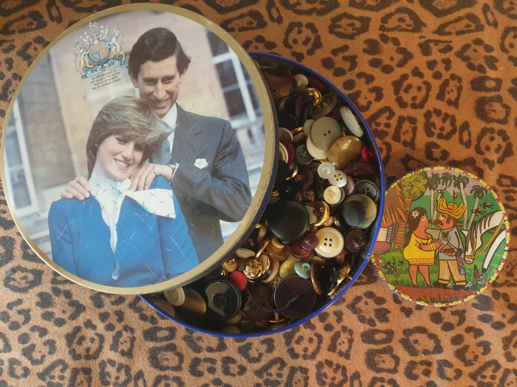 Buttons in a royal memerobilia tin and a charity shopped ornament