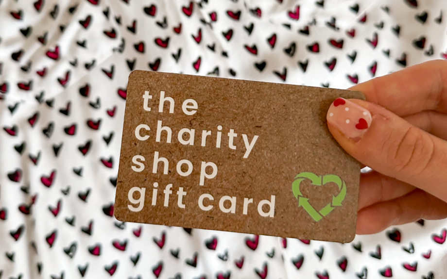 The Charity Shop Gift Card being held against a heart print shirt